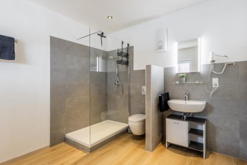 a bathroom with a shower and a toilet and a sink at Ems-Suite 01 I City I WiFi I 4 Personen I Klimaanlage in Warendorf