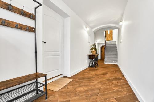 a hallway with white walls and wood floors and a staircase at Studio Jáchymov by Mountain ways in Jáchymov