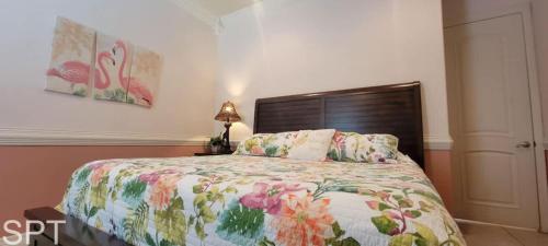 a bedroom with a bed with a floral bedspread at Island Time #4 in South Padre Island