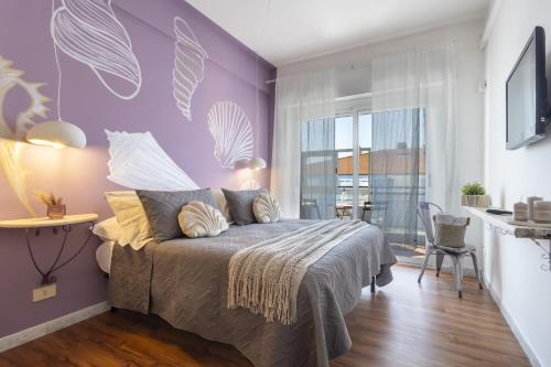 a bedroom with purple walls and a bed with pillows at Conchiglia design vista mare/spiaggia+parking in Diano Marina
