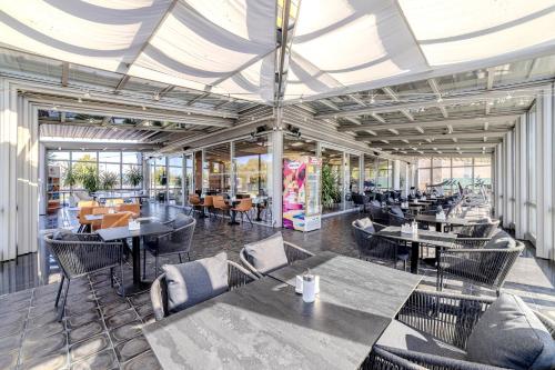 a restaurant with tables and chairs in a building at Hotel Aura Design & Garden Pool in Prague