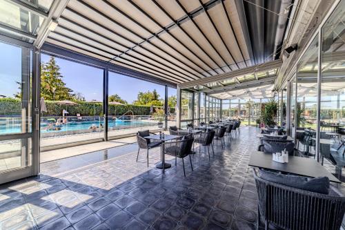 a restaurant with tables and chairs and a pool at Hotel Aura Design & Garden Pool in Prague