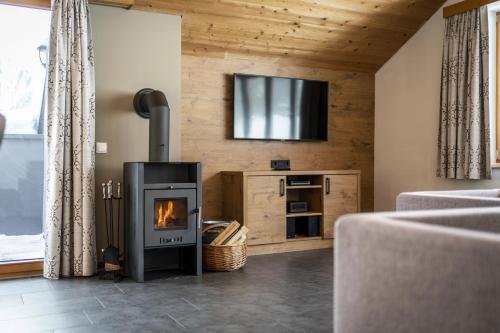 a living room with a fireplace and a tv at Landal Brandnertal in Bürserberg