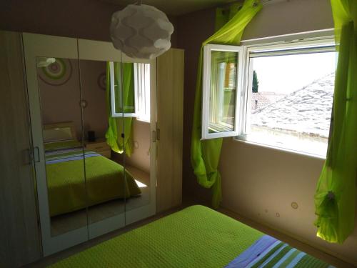 a small bedroom with a mirror and a window at Apartment Tara in Sumartin