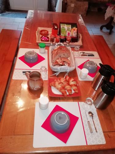 un tavolo in legno con sopra del cibo di LA LONGÈRE - Chambre Aubrac 