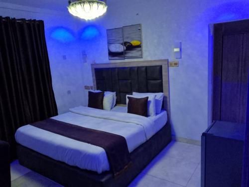 a bedroom with a large bed with blue lighting at RJ hotel in Port Harcourt