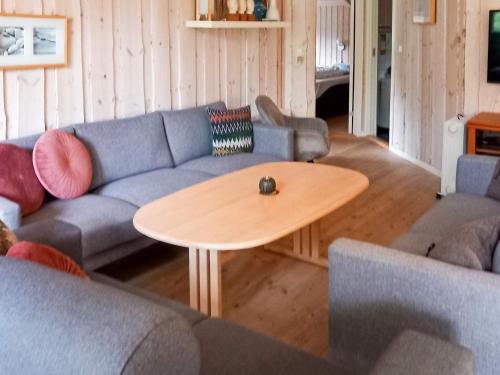 a living room with a blue couch and a wooden table at 4 star holiday home in Ålbæk in Bunken