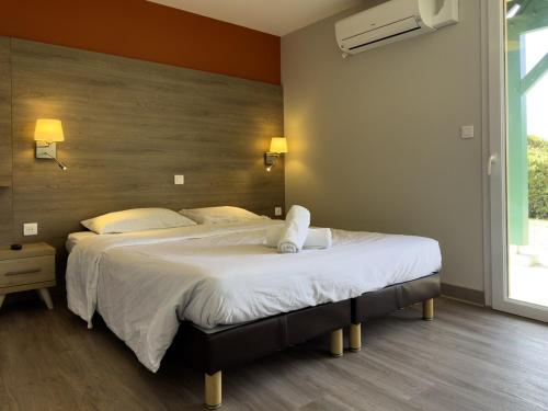 a bedroom with a large bed with white sheets at Grande maison adaptée in Figeac