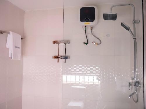 a bathroom with a shower with a speaker on the wall at Captain Residency in Lagos