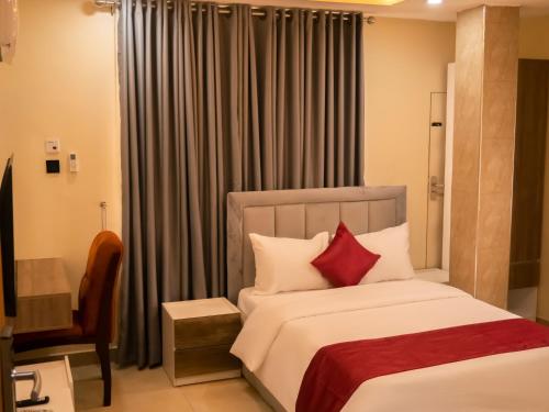 a bedroom with a bed with red pillows at Captain Residency in Lagos