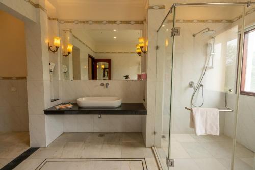 a bathroom with a glass shower and a sink at Hotel Raj Bagh Palace in Jaipur