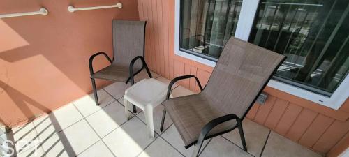 two chairs and a white chair on a balcony at Gulfview I #205 in South Padre Island