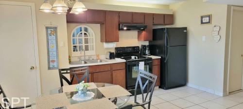 a kitchen with a table and a black refrigerator at Gulfview I #205 in South Padre Island