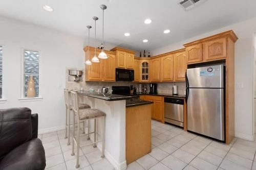 a kitchen with wooden cabinets and a stainless steel refrigerator at Beach & Palms condo in South Padre Island
