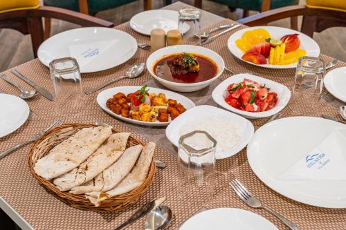 a table topped with white plates and bowls of food at Still Waters Alaya Stays by ELIVAAS in Varkala