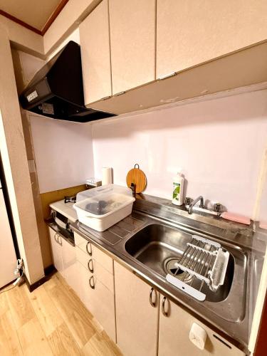 a kitchen with a sink and a counter top at SUN PALACE Fussa 阳光家园 in Fussa