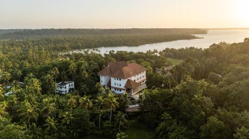 an aerial view of a house on a hill next to a river at Still Waters Alaya Stays by ELIVAAS in Varkala
