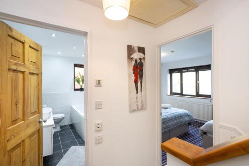 a room with a bathroom with a bed and a mirror at Southernwood House Long Stays Free Parking WiFi in Swindon