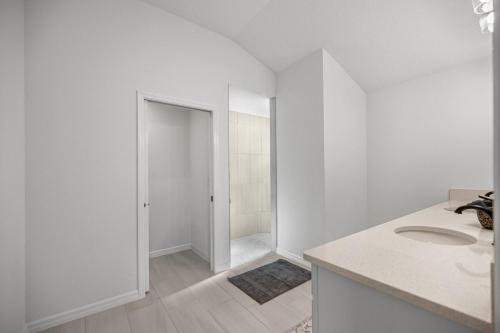 Un baño blanco con lavabo y ducha. en Spacious Lake View 3BR in The Villages With Golf Cart & Patio, en Sumterville