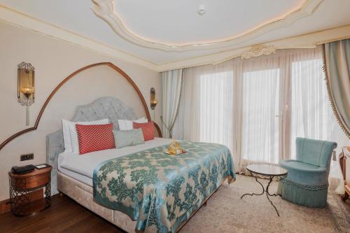 a bedroom with a large bed and a blue chair at Romance Istanbul Hotel Boutique Class in Istanbul