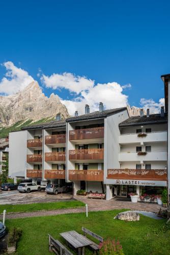 a large building with a mountain in the background at Residence Lastei in San Martino di Castrozza