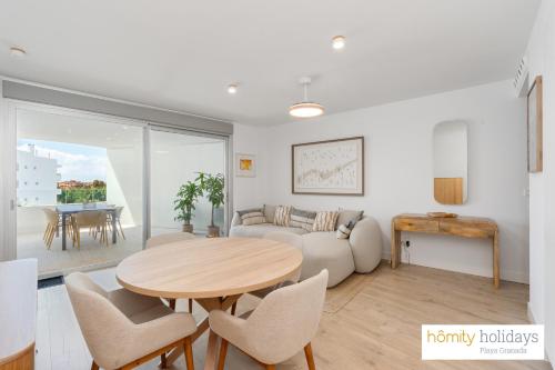 una sala de estar con una mesa y un sofá en Homity Holidays - Playa Granada - Mar de Fabiola, en Motril