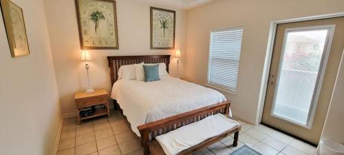 a small bedroom with a bed and a window at Beach & Palms condo in South Padre Island