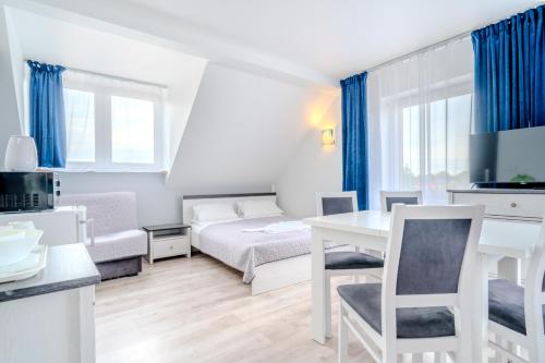 a small apartment with a bed and a table and chairs at Pablo in Niechorze