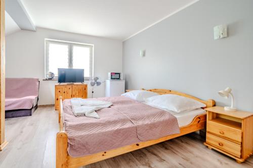 a bedroom with a wooden bed and a television at Pablo in Niechorze