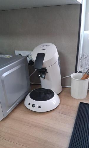 a mixer sitting next to a microwave on a counter at Sleep & Cozy près de Disneyland et des commerces in Coupvray