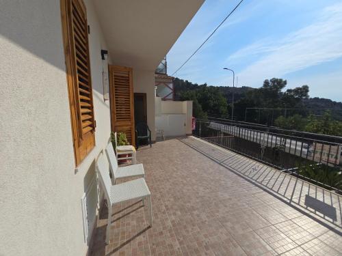 a balcony of a house with a bench on the side at Dal Falegname in Roccalumera
