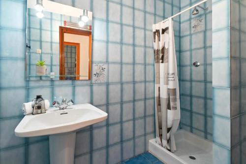 a blue tiled bathroom with a sink and a shower at Jasmin by Aguilarent in Jávea