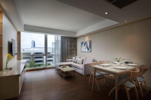 a living room with a table and a couch at Shama Petchburi 47 Bangkok in Bangkok