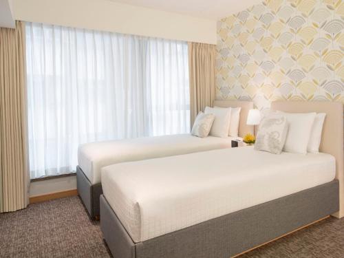 two beds in a hotel room with windows at Shama Island North in Hong Kong