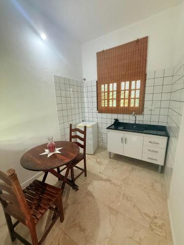 a kitchen with a table and chairs and a sink at POUSO DE ICARO - POUSADA NO CENTRO de PARATY in Paraty