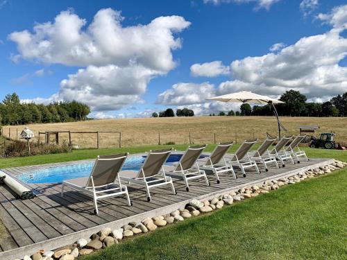 a group of chairs sitting next to a pool at Holiday home in Cetturu with sauna in Cetturu