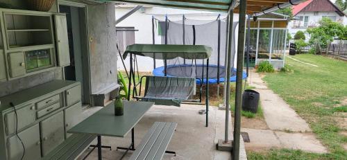 a screened in porch with a swing and a trampoline at Z21 Apartman in Balatonföldvár