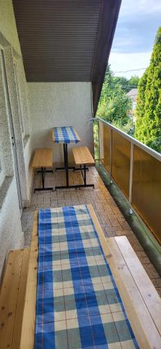 a balcony with a table and benches on a balcony at Z21 Apartman in Balatonföldvár