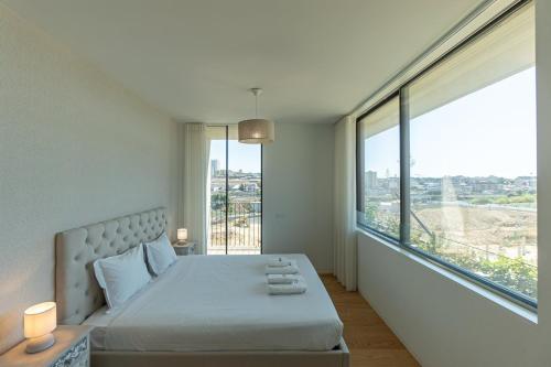 a bedroom with a bed and a large window at GuestReady - Urban luxury with Douro view in Vila Nova de Gaia
