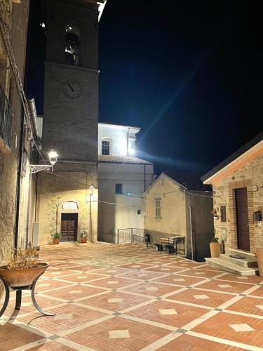 a large courtyard with a clock tower at night at Il Tramonto in Altino