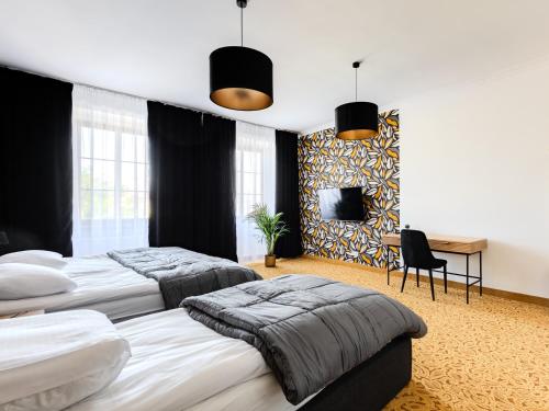 two beds in a bedroom with black walls and a desk at The Old Townhouse III in Krosno