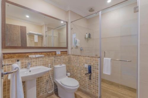 a bathroom with a toilet and a sink and a shower at Still Waters Alaya Stays by ELIVAAS in Varkala