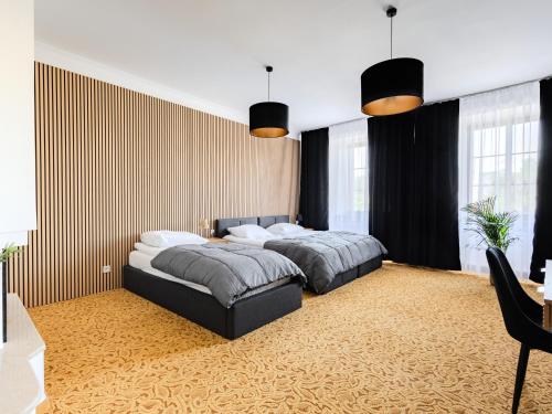 a bedroom with two beds and a desk and windows at The Old Townhouse III in Krosno