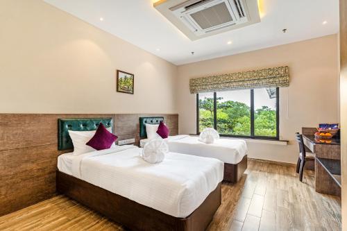 two beds in a hotel room at Still Waters Alaya Stays by ELIVAAS in Varkala