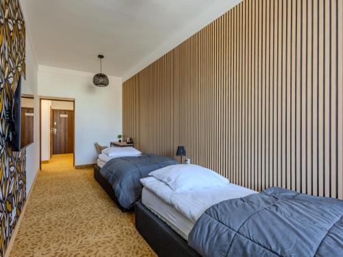three beds are lined up in a room at The Old Townhouse III in Krosno