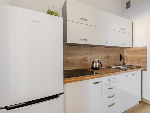 a kitchen with white cabinets and a refrigerator at The Old Townhouse III in Krosno
