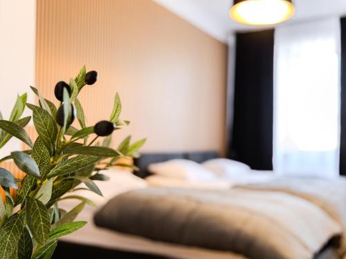 a bedroom with a bed and a plant in the foreground at The Old Townhouse III in Krosno