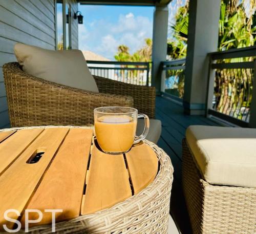 a cup of tea sitting on a wooden table on a porch at Luxury Remodel - Sleeps 20 - Pool - Go VIP in South Padre Island