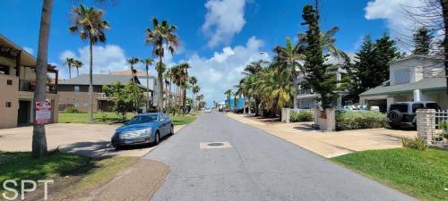 a car parked on the side of a street with palm trees at Luxury Remodel - Sleeps 20 - Pool - Go VIP in South Padre Island