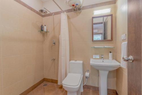 a bathroom with a toilet and a sink at Still Waters Alaya Stays by ELIVAAS in Varkala
